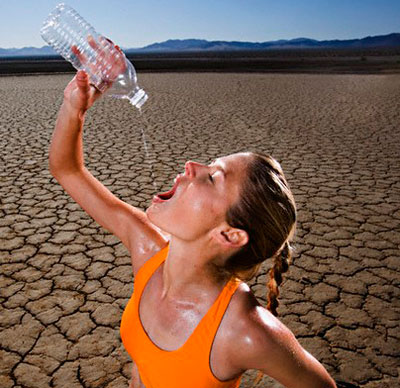 Девушка пьёт воду в пустыне